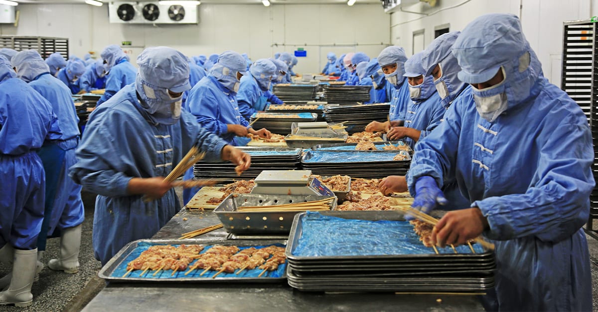 Workers In A Meat Processing Production Line Wearing PPE